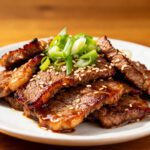 Air fryer bulgogi beef slices glazed with Korean style sauce and topped with green onions and sesame seeds