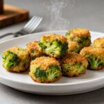 Crispy air fryer broccoli tots with a cheesy center and golden breadcrumb coating served on a plate