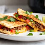 Crispy air fryer beef quesadilla filled with seasoned ground beef, melted cheese, peppers, and onions