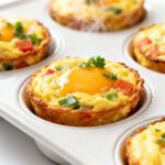 Air fryer egg muffin cups baked with eggs, cheese, and colorful vegetables for a protein packed breakfast