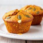 Soft air fryer pumpkin muffins topped with pumpkin seeds and baked until golden and fluffy
