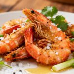 Crispy air fryer salt and pepper shrimp seasoned with coarse salt, cracked pepper, and fresh herbs