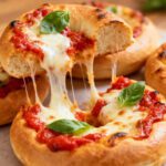 Homemade air fryer pizza bagels topped with melted mozzarella cheese, tomato sauce, and fresh basil