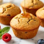 Healthy air fryer muffins with a soft fluffy texture, mixed berries, and a light honey drizzle