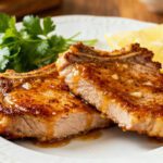 Juicy air fryer honey garlic pork chops glazed with a sweet savory sauce and served with fresh lemon wedges