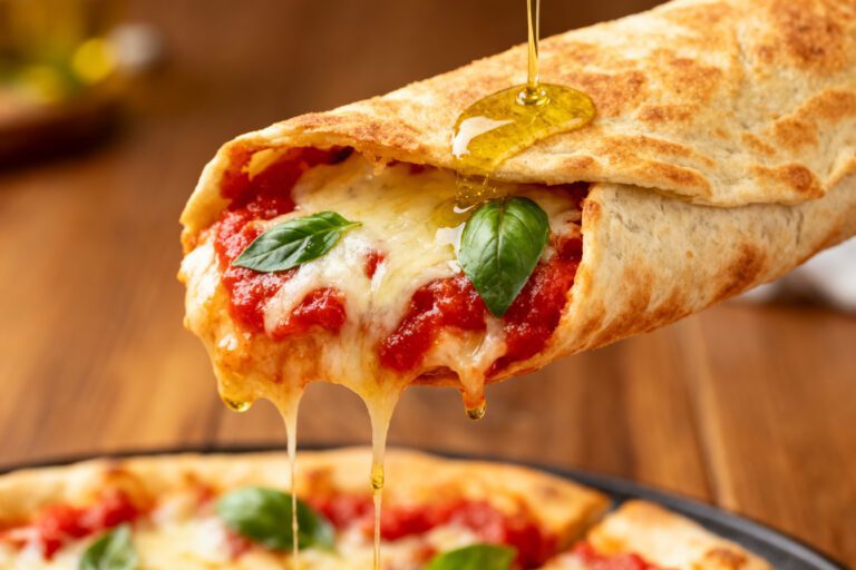 Air fryer pizza wrap filled with melted mozzarella cheese, pizza sauce, and fresh basil in a crispy tortilla