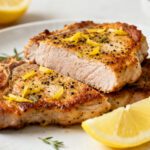 Juicy air fryer lemon pepper pork chops seasoned with cracked pepper, fresh lemon zest, and herbs