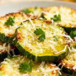 Crispy air fryer parmesan zucchini slices topped with melted parmesan cheese and fresh herbs