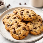 Chocolate chip cookies with golden edges and melted chocolate chips served on a plate