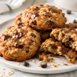 Oatmeal chocolate chip cookies with melted dark chocolate chunks on a white plate
