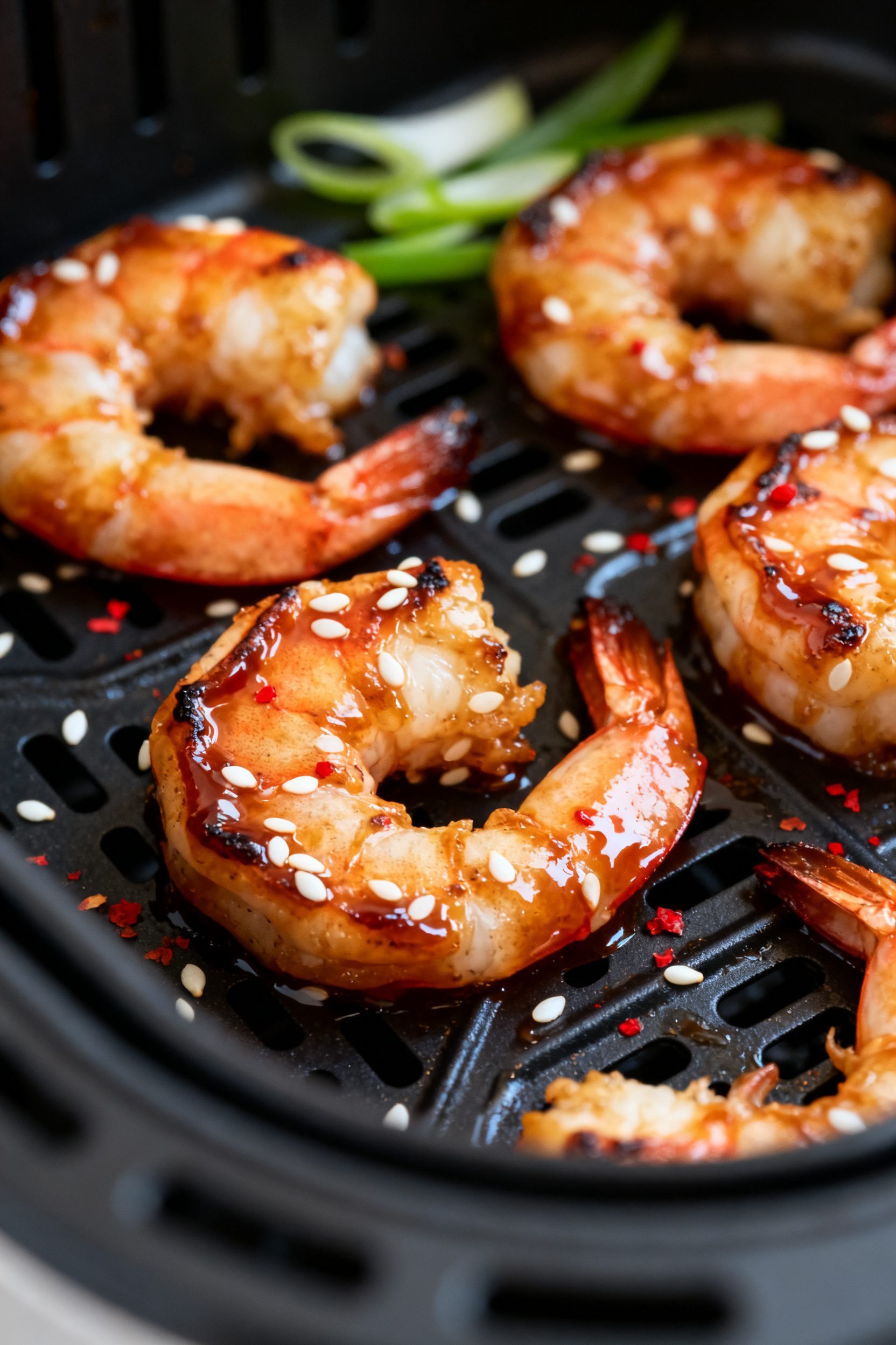Close-up detail shot: Air fryer teriyaki shrimp just out of the basket, cooked to a glossy carameliz