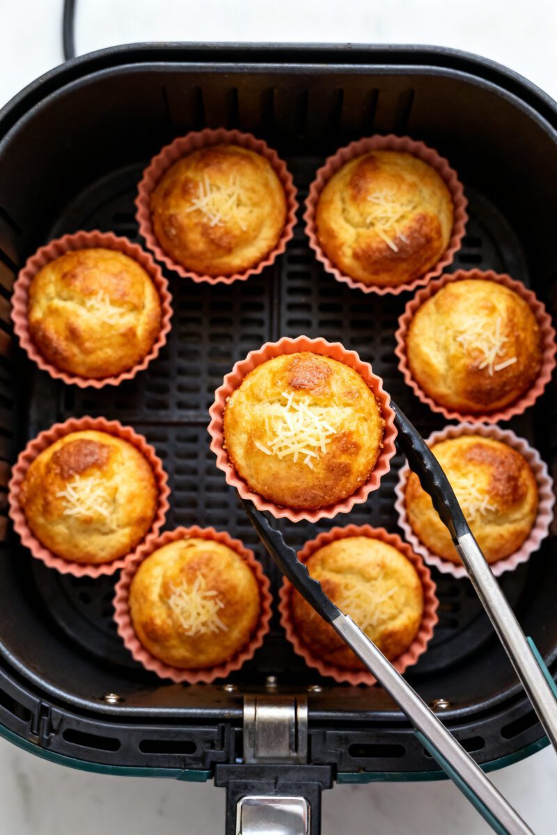 Cooking process: Overhead shot of silicone muffin cups arranged with space in an air fryer basket at