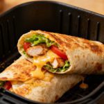 Cheesy garlic chicken wraps made in the air fryer with juicy chicken, melted cheese, crisp lettuce, and tomatoes