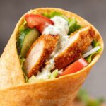 Air fryer chicken shawarma wrap filled with seasoned chicken, fresh vegetables, and creamy garlic sauce in a warm tortilla
