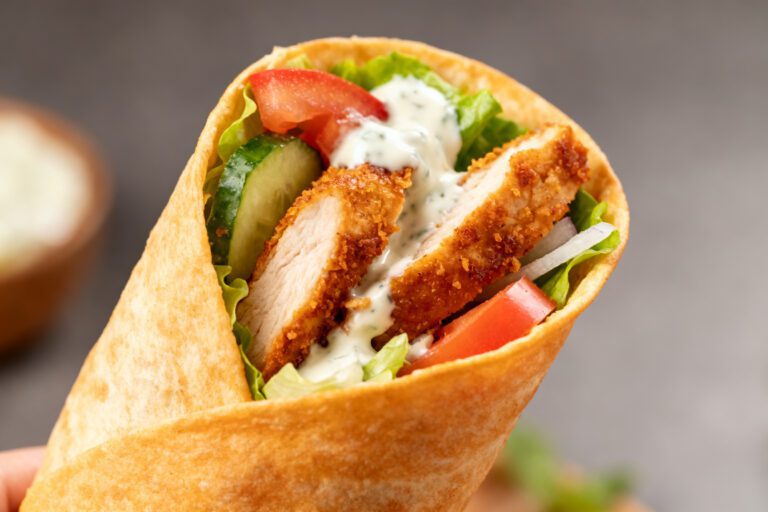 Air fryer chicken shawarma wrap filled with seasoned chicken, fresh vegetables, and creamy garlic sauce in a warm tortilla