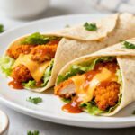 Air fryer buffalo chicken wraps filled with crispy buffalo chicken, lettuce, melted cheese, and spicy buffalo sauce