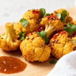 Indian style air fryer cauliflower with crispy roasted florets, warm spices, cilantro, and chili flakes