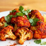 Air fryer tandoori cauliflower with crispy roasted florets, bold Indian spices, fresh cilantro, and lemon wedges