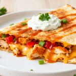 Air fryer buffalo chicken quesadilla filled with spicy buffalo chicken, melted cheese, peppers, and creamy ranch topping