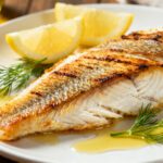 Air fryer tilapia fillets with crispy golden skin, tender flaky fish, fresh dill, and lemon wedges