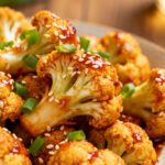 Air fryer Korean cauliflower coated in a sticky spicy sauce and topped with sesame seeds and green onions