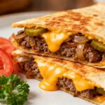 Air fryer cheeseburger quesadilla with seasoned ground beef, melted cheddar cheese, pickles, onions, and crispy golden tortillas