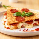 Air fryer pepperoni pizza quesadilla with melted mozzarella cheese, crispy pepperoni, pizza sauce, and golden tortillas