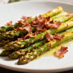 Air fryer asparagus with bacon featuring tender roasted asparagus spears, crispy bacon pieces, and savory seasoning