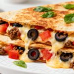 Air fryer supreme pizza quesadilla with seasoned beef, melted mozzarella cheese, black olives, tomatoes, and crispy golden tortillas