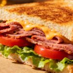 Air fryer bologna sandwich with crispy bologna, melted cheddar cheese, fresh lettuce, tomatoes, and toasted bread
