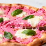 Air fryer pink pizza topped with creamy pink sauce, melted mozzarella cheese, and fresh basil leaves