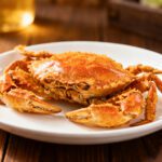 Crispy air fryer soft shell crab with a golden brown coating, served on a white plate and cooked until crunchy and tender inside.