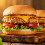 Air fryer turkey burgers with juicy seasoned turkey patties, melted cheddar cheese, fresh lettuce, and tomato slices on soft burger buns.