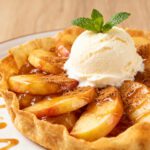 Air fryer apple tortilla dessert with cinnamon spiced apple slices, a crispy tortilla crust, caramel drizzle, and a scoop of vanilla ice cream on top.