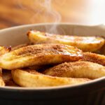 Air fryer cinnamon sugar bananas with caramelized golden edges, warm cinnamon coating, and a soft tender center, served in a bowl as a cozy and satisfying dessert.