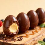 Air fryer Cadbury eggs with a warm melted chocolate shell and soft creamy center, served with fresh berries and chocolate shavings for an easy seasonal treat.