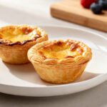 Air fryer mini pies with flaky golden pastry crusts and a rich savory filling, baked until crisp and perfectly portioned, served on a white plate.