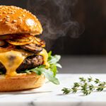 Air fryer portobello mushroom burger with a juicy grilled portobello cap, melted cheese, caramelized onions, fresh greens, and a toasted sesame bun, served as a hearty vegetarian meal.