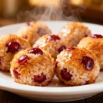 Air fryer cherry rice balls with a crispy golden exterior, sweet cherry filling, tender rice center, and a glossy glaze, served as a unique sweet treat with warm comforting flavor.