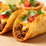 Air fryer frozen mini tacos with crispy golden taco shells, seasoned beef filling, melted cheese, diced tomatoes, and fresh cilantro, served as a quick and easy snack or meal.