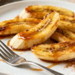 Air fryer caramelized bananas with golden brown edges, a soft tender center, warm cinnamon, and a sweet caramel drizzle, served as a quick and comforting dessert.