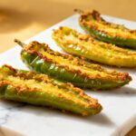 Air fryer fried banana peppers with a crispy seasoned coating, tender roasted pepper halves, and tangy flavor, served as a quick appetizer or savory snack with lemon wedges.