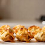 Air fryer mini wontons with crispy golden wrappers and savory filling, cooked until crunchy and lightly browned, served as a crowd pleasing appetizer or snack.