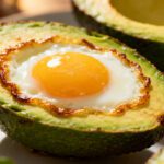 Air fryer egg in avocado with a perfectly cooked sunny egg nestled in a creamy avocado half, featuring lightly roasted edges and a rich satisfying texture for breakfast.