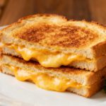 Texas toast grilled cheese in the air fryer with thick golden toasted bread and layers of melted cheddar cheese, served hot with a crispy buttery crust and gooey center.