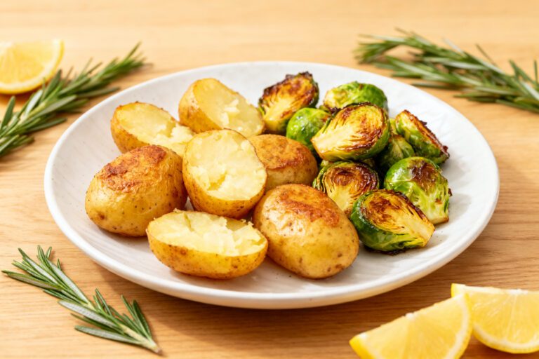 Air fryer potatoes and Brussels sprouts with crispy roasted baby potatoes, caramelized Brussels sprouts, fresh rosemary, and lemon accents, served as a flavorful and easy vegetable side dish.