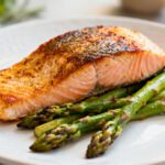 Air fryer salmon and asparagus with a flaky seasoned salmon fillet, tender roasted asparagus spears, and lightly charred edges, served as a quick and flavorful weeknight dinner.