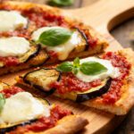 Air fryer eggplant pizza with crispy pizza crust, roasted eggplant slices, rich tomato sauce, melted mozzarella cheese, and fresh basil leaves, served as a satisfying vegetarian meal.