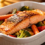 Air fryer salmon and vegetables with a flaky seasoned salmon fillet, roasted broccoli, carrots, and bell peppers, served as a colorful and flavorful one pan weeknight dinner.