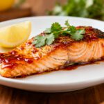 Air fryer sweet chili salmon with a flaky tender salmon fillet, glossy sweet chili glaze, fresh cilantro garnish, and lemon wedge, served as a flavorful and easy weeknight seafood dinner.